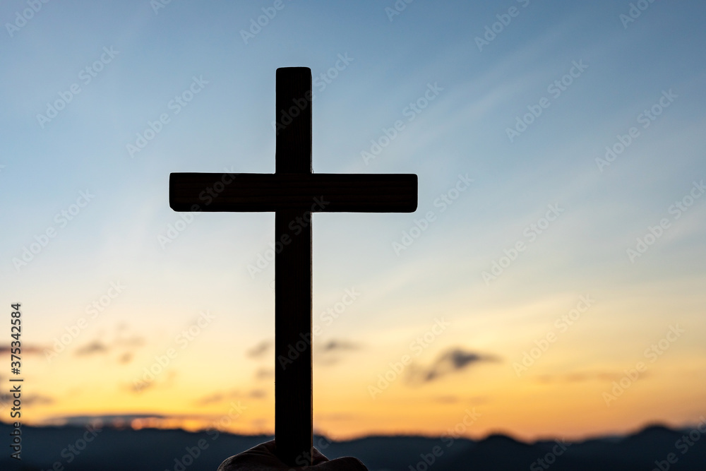 Silhouettes of a crucifix symbol with bright sunbeam on the sky Silhouettes of a crucifix symbol with bright sunbeam on the sky