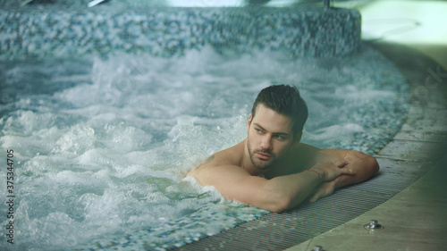 Man relaxing in spa on vacation. Male resting in jacuzzi at wellness center © stockbusters
