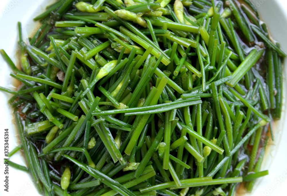 Top view of stir fried Chinese chives flowers. Chinese chives have another name is Garlic chive, Oriental garlic, Chinese leet, Asian chive. Top view of stir fried Chinese chives flowers. Chinese chives have another name is Garlic chive, Oriental garlic, Chinese leet, Asian chive.