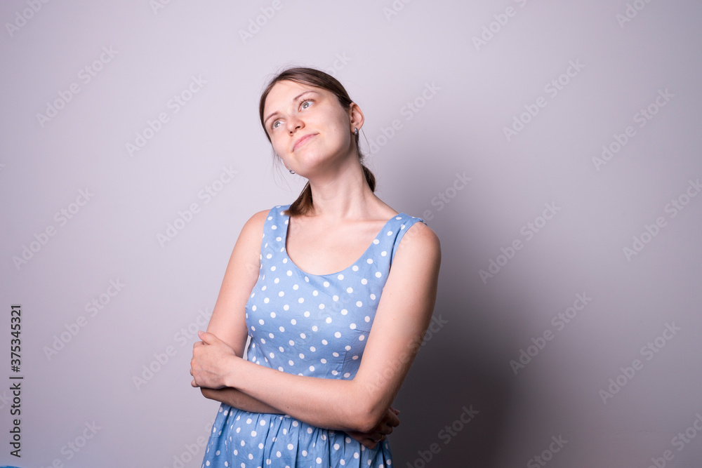 young girl in a blue dress with a pony tail in studio