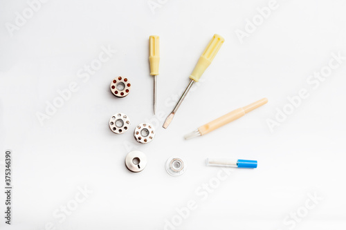A group of accessories for a sewing machine on a white background.