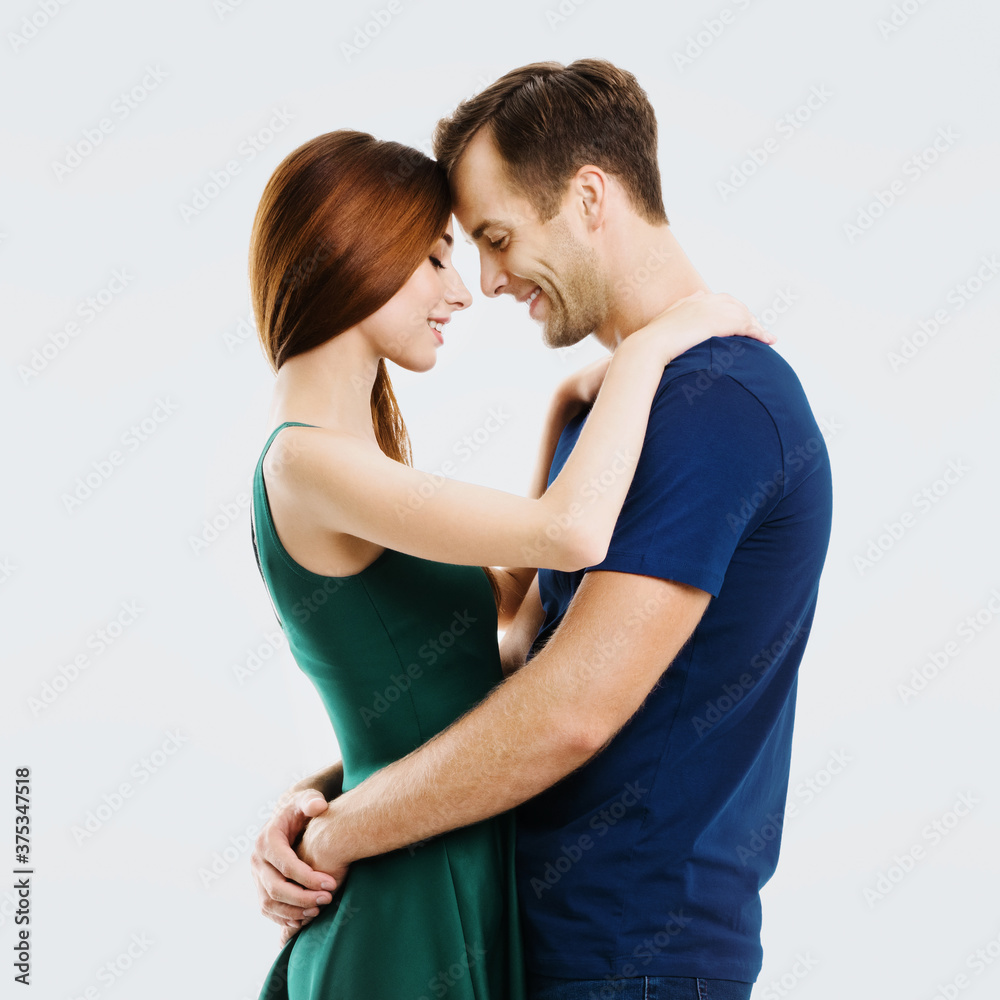 Happy amazed young amorous couple. Portrait image of embracing models with closed eyes, at happy in love studio concept, isolated over grey background. Man and woman dancing. Square composition. Happy amazed young amorous couple. Portrait image of embracing models with closed eyes, at happy in love studio concept, isolated over grey background. Man and woman dancing. Square composition.
