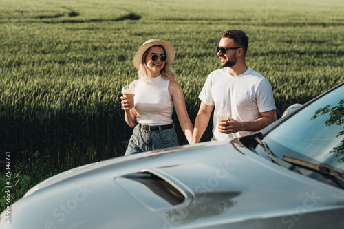 Man and Woman Having Good Time Near Their Car, Drinking Cold Coffee and Enjoying Adventure Road Trip