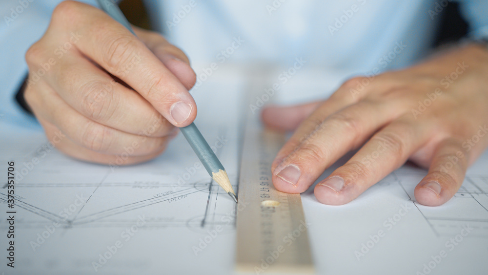 Architect's hands drawing a construction plan Architect's hands drawing a construction plan