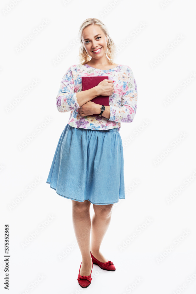 Young girl with a book in her hand. Smiling blonde with ponytails on her head. Knowledge and education. Back to school. Full height. Vertical. White background. Young girl with a book in her hand. Smiling blonde with ponytails on her head. Knowledge and education. Back to school. Full height. Vertical. White background.