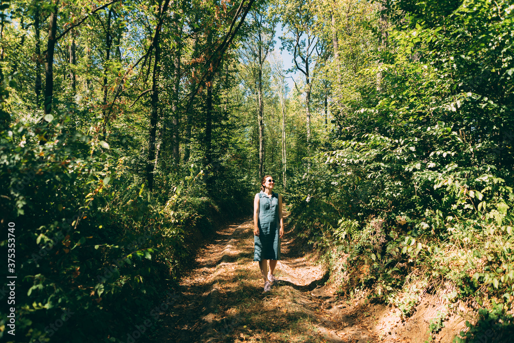 Photo of young beautiful woman walking in forest and relaxing Photo of young beautiful woman walking in forest and relaxing