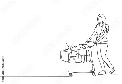 One continuous line drawing young happy female pushing trolley at supermarket while shopping fruits, vegetables, breads, milk. Shopping in hypermarket concept. Single line draw design illustration