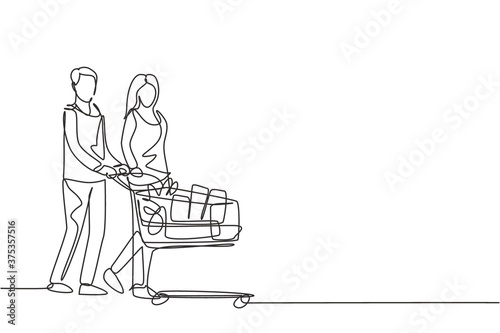 One continuous line drawing young happy romantic couple pushing trolley full of daily goods, vegetables, fruits, milk together. Shopping in grocery store concept. Single line draw design illustration