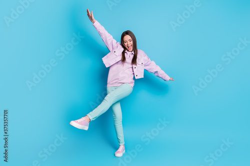 Full length body size view of her she nice attractive pretty carefree cheerful cheery glad teenage girl having fun walking dancing isolated on bright vivid shine vibrant blue color background