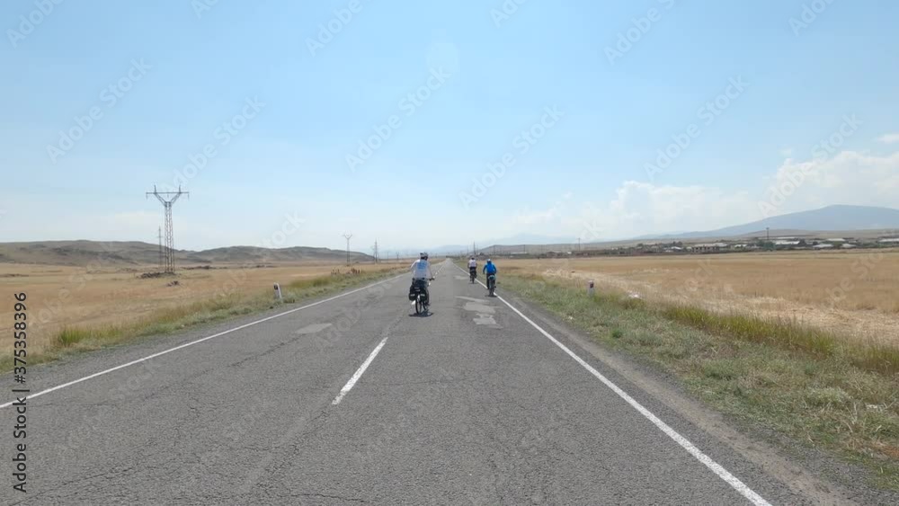 Cyclists on bicycles.Three cyclist riding on empty way.Road between fields.View from bag.Concept activity, health, sports, relax vacation travel. Action camera go pro. Trail adventure. Cyclists on bicycles.Three cyclist riding on empty way.Road between fields.View from bag.Concept activity, health, sports, relax vacation travel. Action camera go pro. Trail adventure.
