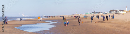 Noordwijk, Netherlands: sunny clear winterday at the beach; on the horizon smoke stacks in IJmuiden and buildings of Zandvoort photo