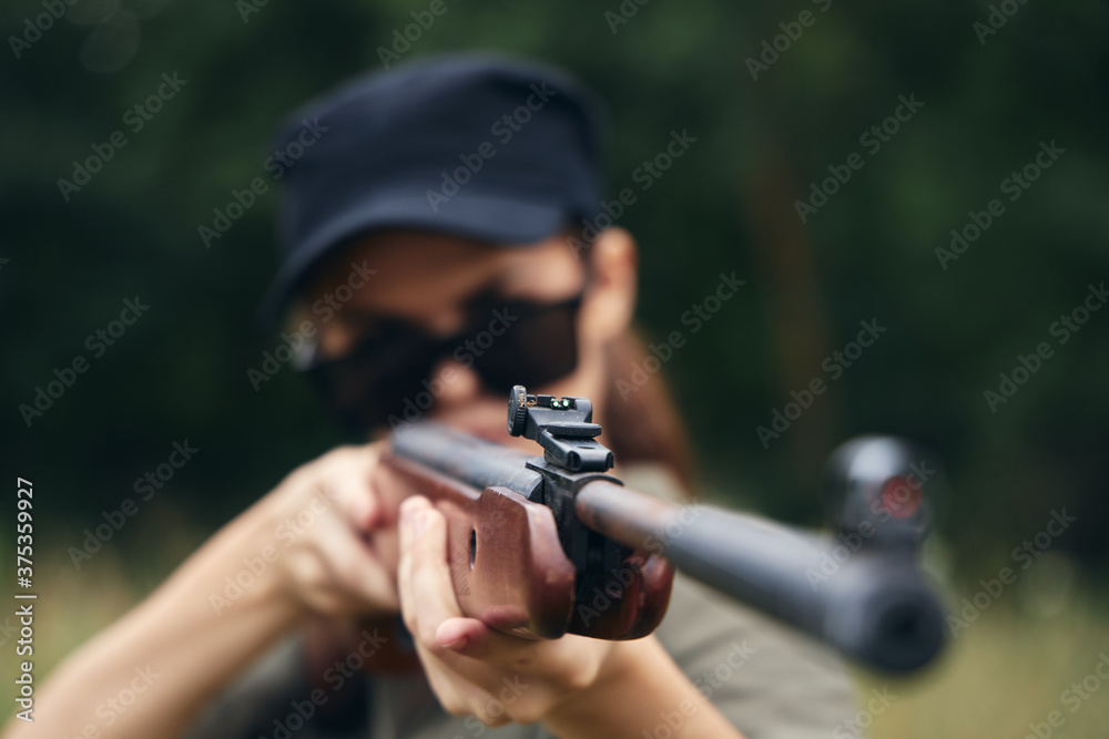 Woman soldier muzzle weapon sight hunting target green leaves Woman soldier muzzle weapon sight hunting target green leaves