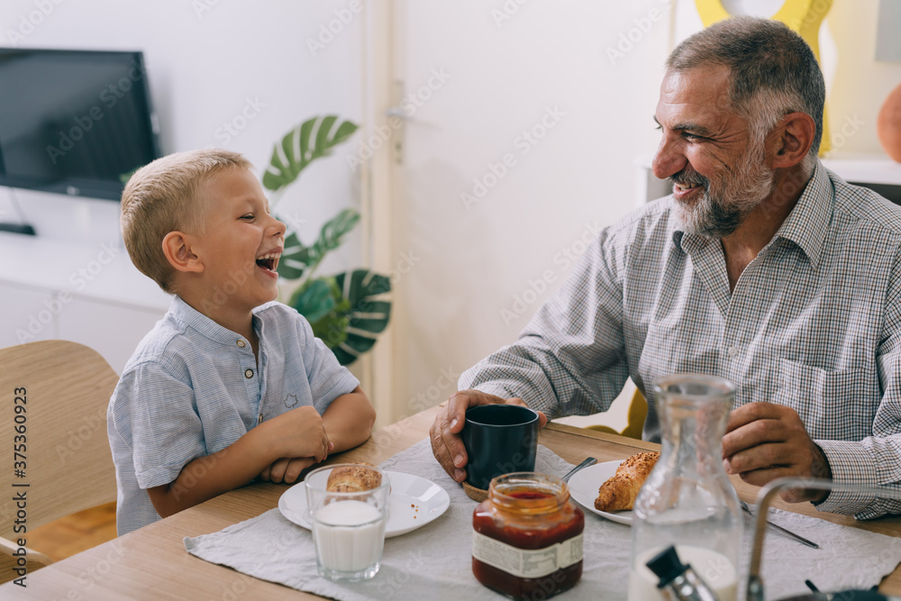 grandfather and grandson having breakfast at home grandfather and grandson having breakfast at home