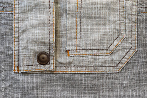 Linen fabric texture. Close-up. A fragment of linen cloth. Rough fabric texture. Double machine stitching on fabric. Decorative elements of trousers. Loose threads. A series of photographs. Flat lay