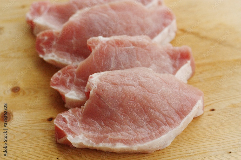 Fresh pork escalope on a wooden table Fresh pork escalope on a wooden table