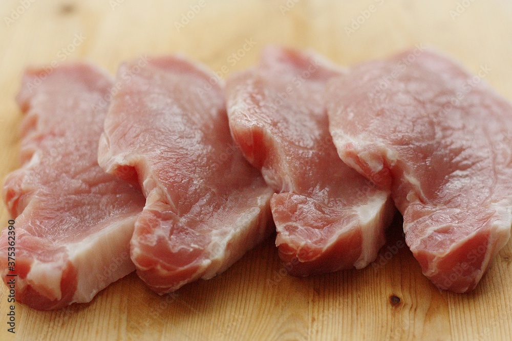 Fresh pork escalope on a wooden table