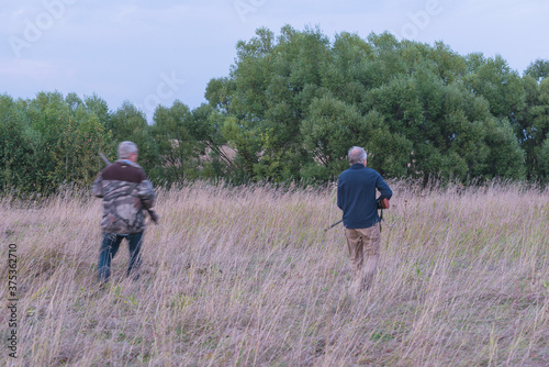 Two mens going on the hunting, back view. Blurred © stsvirkun