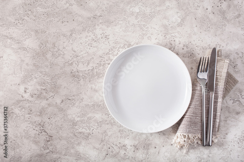 empty plate fork knife on concrete background photo