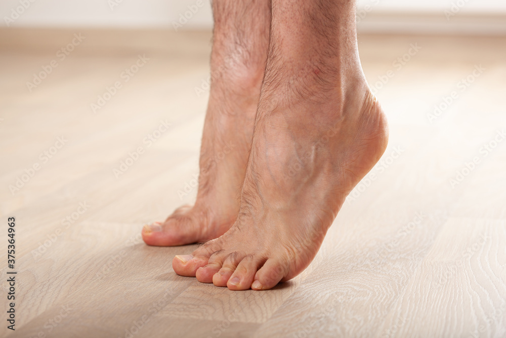 man doing flatfoot correction gymnastic exercise standing on toes at home man doing flatfoot correction gymnastic exercise standing on toes at home