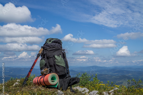 Tourist backpack on the background of mountains and cloudy sky.