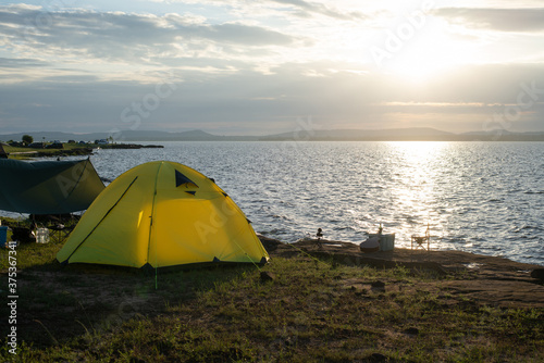 Camping by the sea, Tent on coast at sunrise.