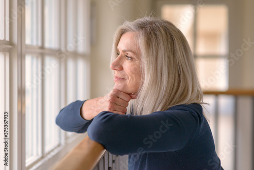 Attractive blond woman watching through a window