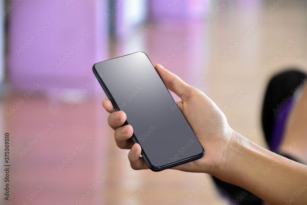 Blank and black screen of mobile phone in hand, conpept for shopping online or learning online.