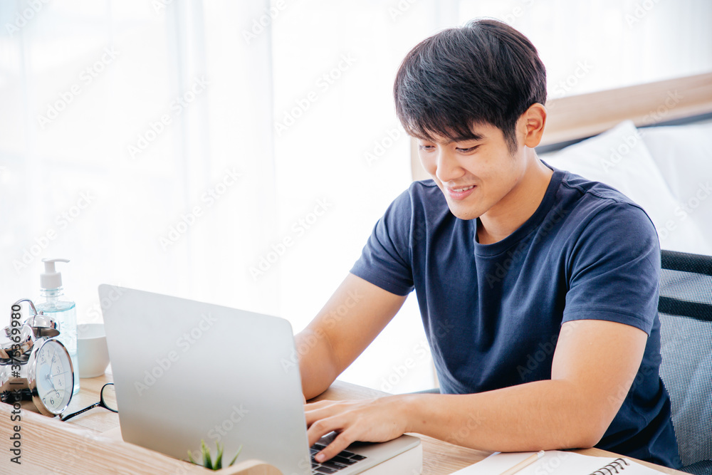 Serious man writing notebook on desk in the Bedroom. COPY SPACE. Trading. Working. WORK FROM HOME Concept. Serious man writing notebook on desk in the Bedroom. COPY SPACE. Trading. Working. WORK FROM HOME Concept.