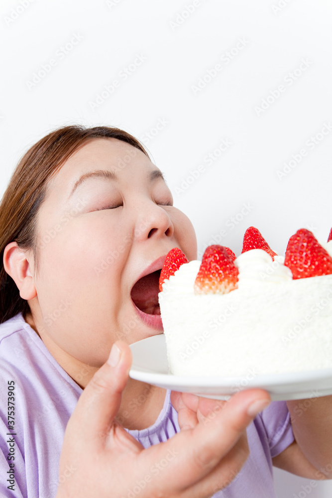ケーキにかぶりつくメタボ女性 ケーキにかぶりつくメタボ女性