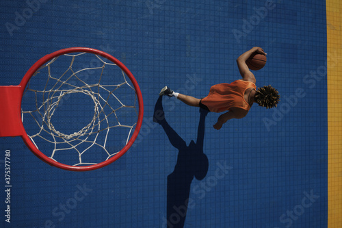 Image of african american guy playing basketball on city sports ground © Drobot Dean