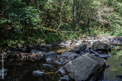 River course littered with rocks with waterfall in Siegerland