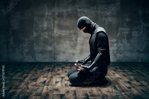 фотографія Warrior man sitting on floor posing with a sword