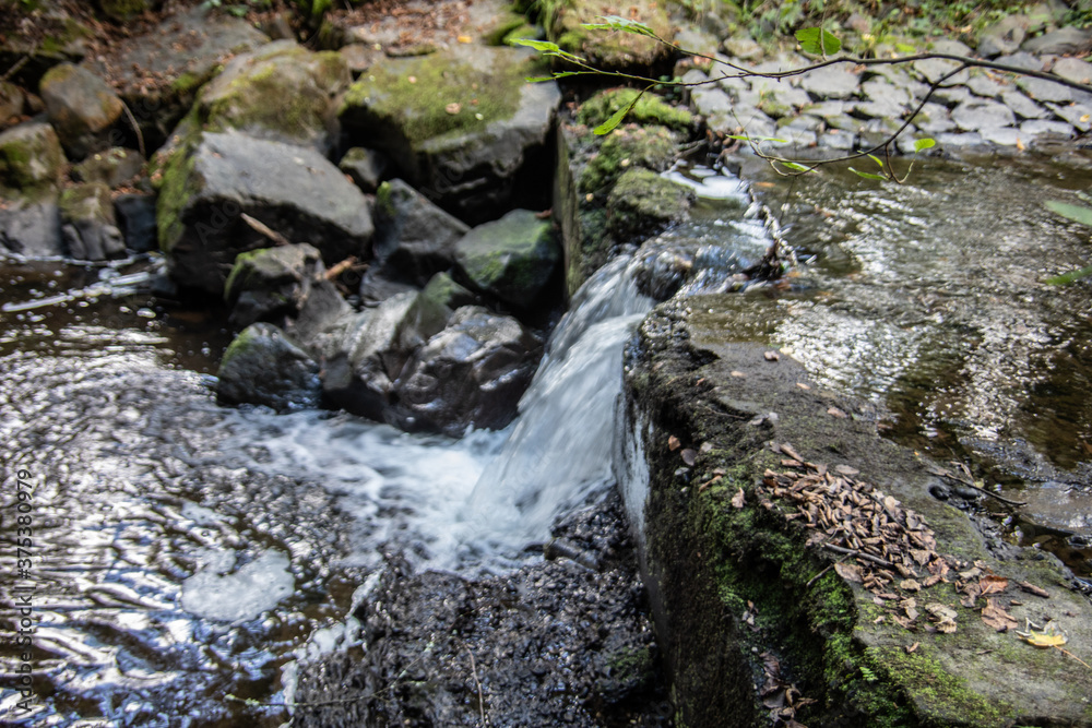 River course littered with rocks with waterfall in Siegerland