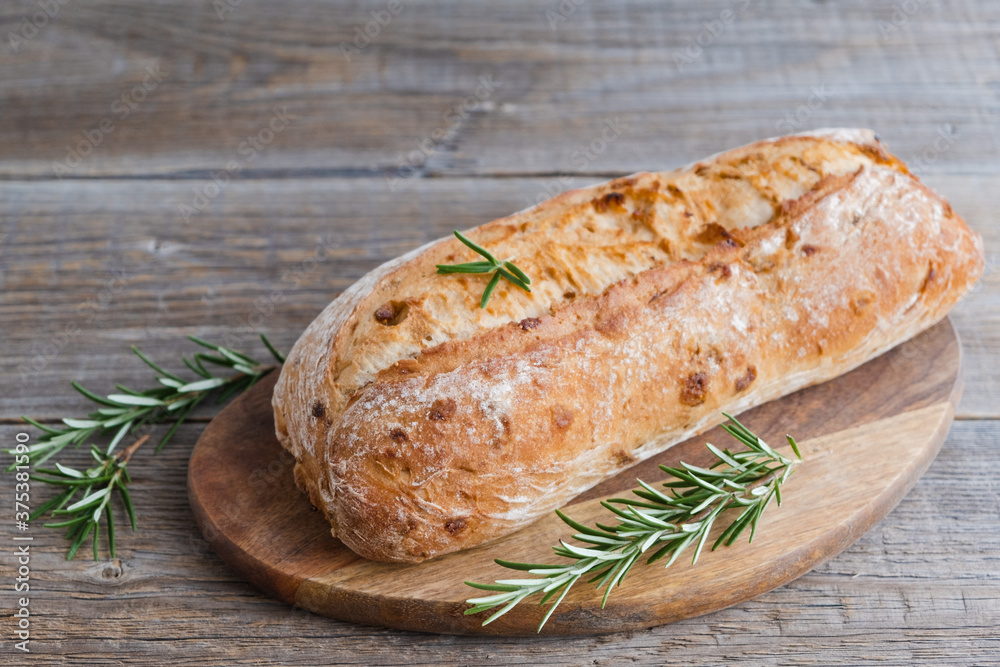 Homemade fresh crispy italian ciabatta with rosemary sprigs on a wooden board. Copy space Homemade fresh crispy italian ciabatta with rosemary sprigs on a wooden board. Copy space
