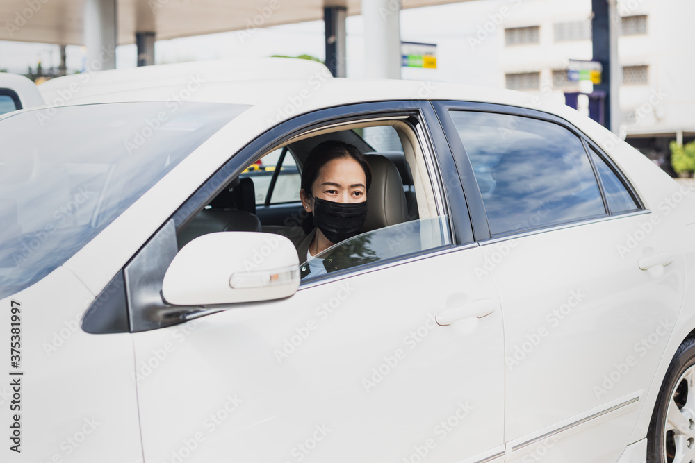 Coronavirus pandemic concept woman with protective mask sit in a car road trip travel.