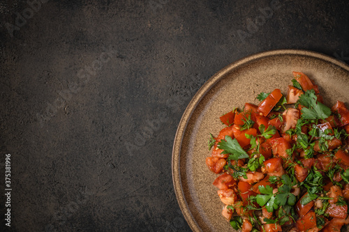 Fresh tomato salad with parsley, coriander, dill, spring onion and ground cumin. Moroccan tomato salad. Top view. Copy space