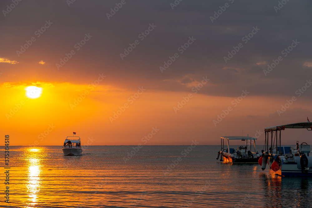 Tropical Sunset with boats in silhouette