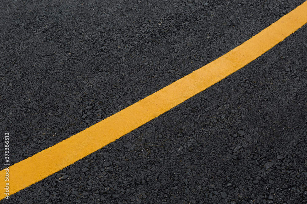 Yellow line on asphalt road texture background Yellow line on asphalt road texture background