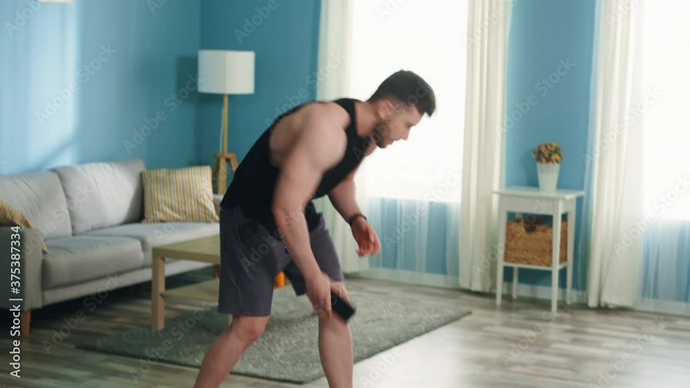 Young athletic man is workouting regularly using his mobile phone, gadget, stands in elbow plank, improve his body shape, enjoys sport and active healthy lifestyle, Slow motion. Young athletic man is workouting regularly using his mobile phone, gadget, stands in elbow plank, improve his body shape, enjoys sport and active healthy lifestyle, Slow motion.