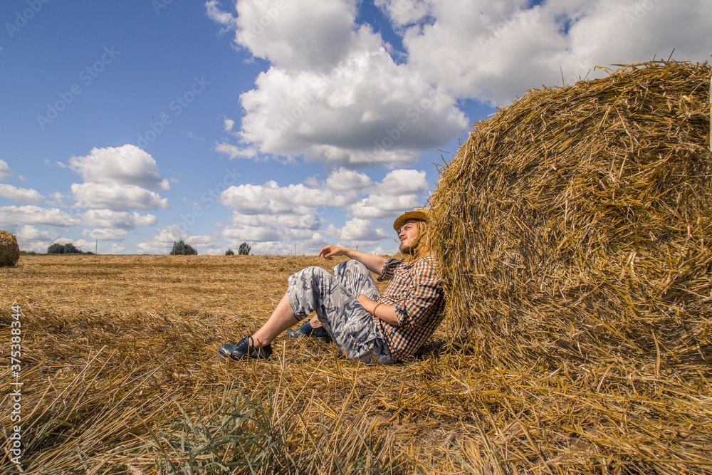 A young bearded man in cowboy hat with wheat roll A young bearded man in cowboy hat with wheat roll