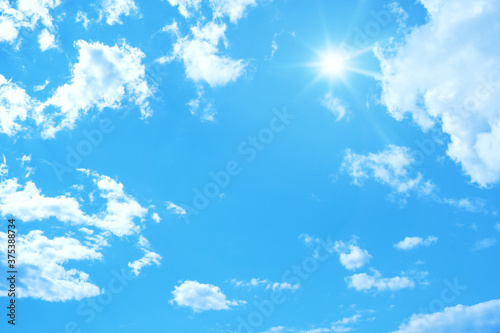 typical blue sky with sun and clouds background