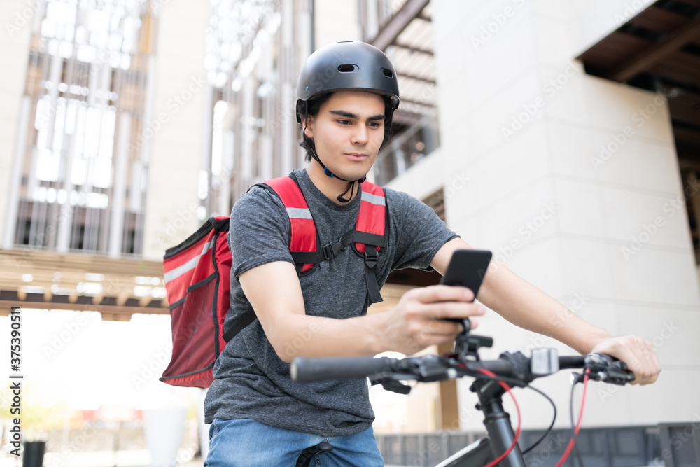 Delivery Man Using Mobile Phone On Bicycle Delivery Man Using Mobile Phone On Bicycle