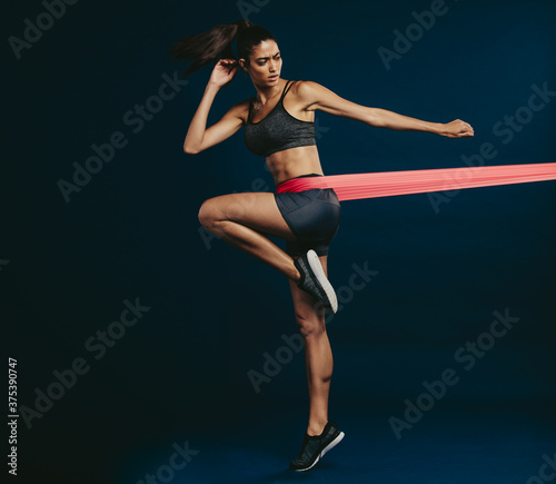 Healthy woman working out with resistance band