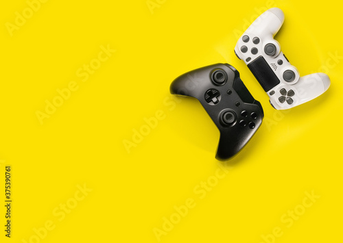 Top view black and white  controllers on yellow background photo