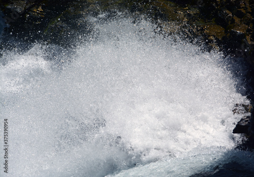 spectacular water splashes in a mountain waterfall © aliberti