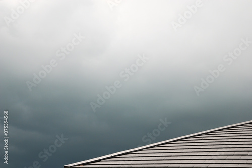 Modern dark brown ceramic tile rooftop in stormy sky background. 
