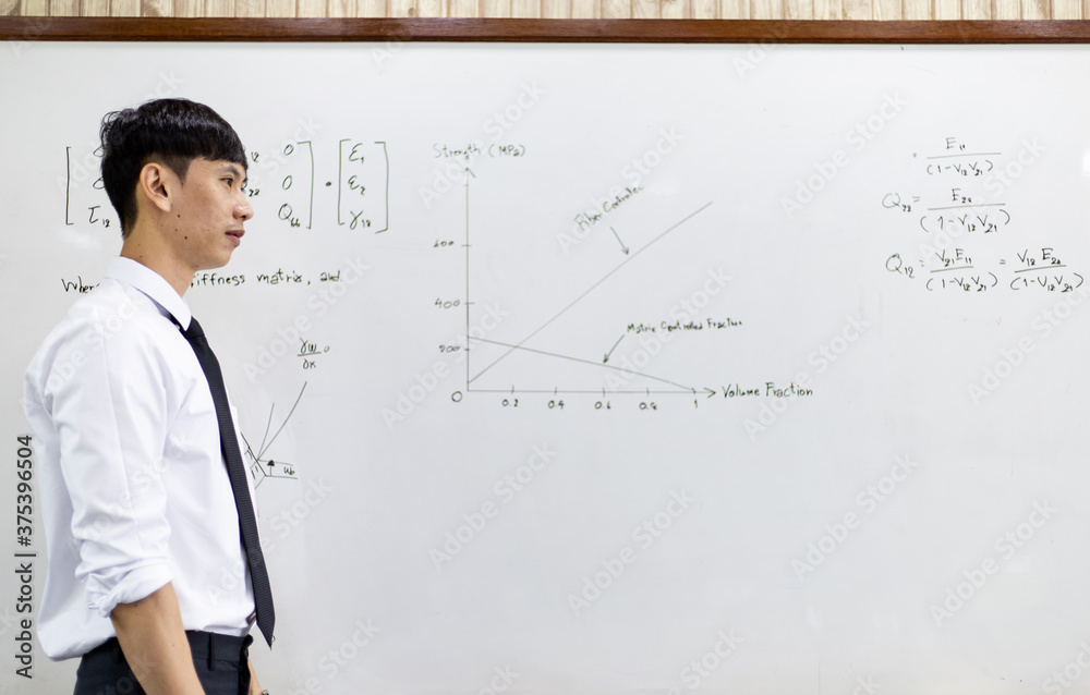 Asian teacher is teaching and writing on a whiteboard. Asian teacher is teaching and writing on a whiteboard.