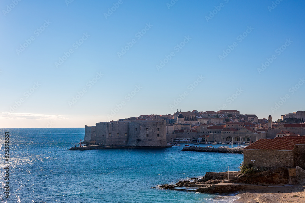 Panoramic high angle view from outside, clear blue-sky sunny day. Scenery winter view of Mediterranean old city of Dubrovnik, famous European travel and historic destination, Croatia Panoramic high angle view from outside, clear blue-sky sunny day. Scenery winter view of Mediterranean old city of Dubrovnik, famous European travel and historic destination, Croatia