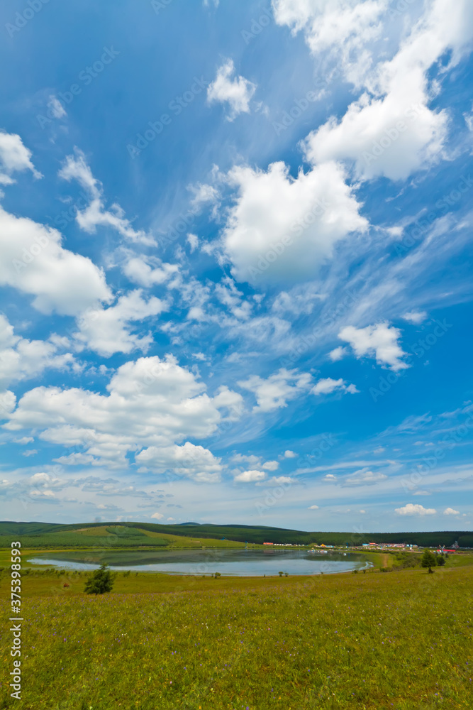 lake and green grass under the blue sky and white clouds