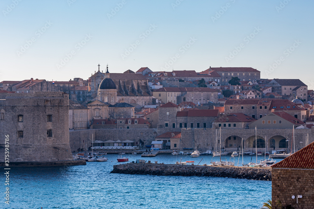 Panoramic detailed view with churches from outside, clear blue-sky sunny day. Scenery winter view of Mediterranean old city of Dubrovnik, famous European travel and historic destination, Croatia